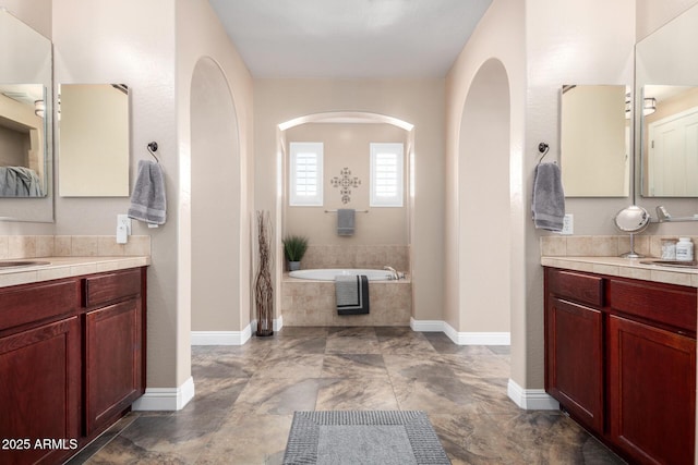 bathroom with vanity and a relaxing tiled tub