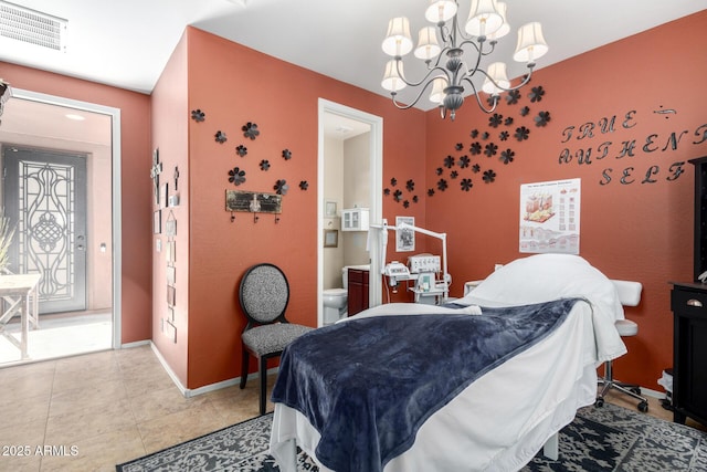 tiled bedroom featuring connected bathroom and a chandelier