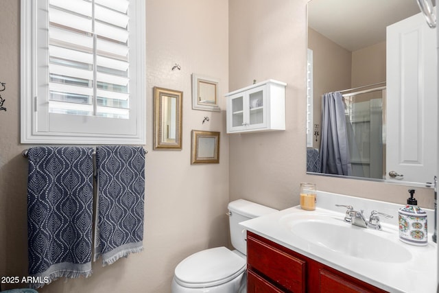 bathroom with a shower, vanity, and toilet