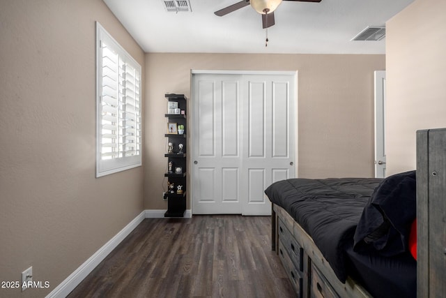 bedroom featuring dark hardwood / wood-style flooring, ceiling fan, and a closet