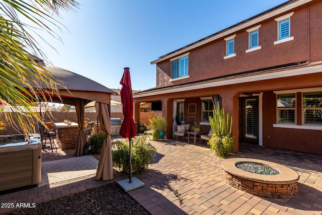 view of patio with a gazebo, a fire pit, and exterior bar