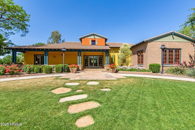 rear view of property with a yard and a patio