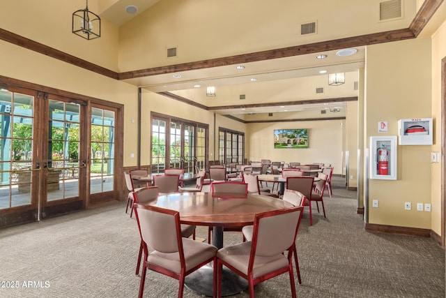 dining space featuring carpet flooring, a high ceiling, and french doors