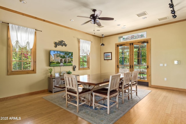 dining room with ceiling fan, french doors, rail lighting, crown molding, and light hardwood / wood-style floors