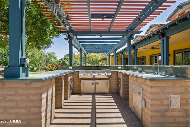 view of patio with ceiling fan, a pergola, sink, and an outdoor kitchen