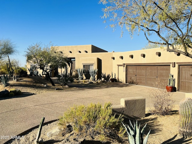 pueblo revival-style home featuring a garage