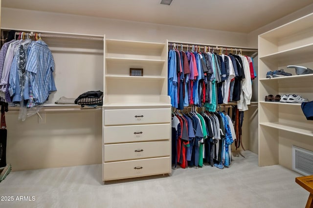 walk in closet featuring light colored carpet