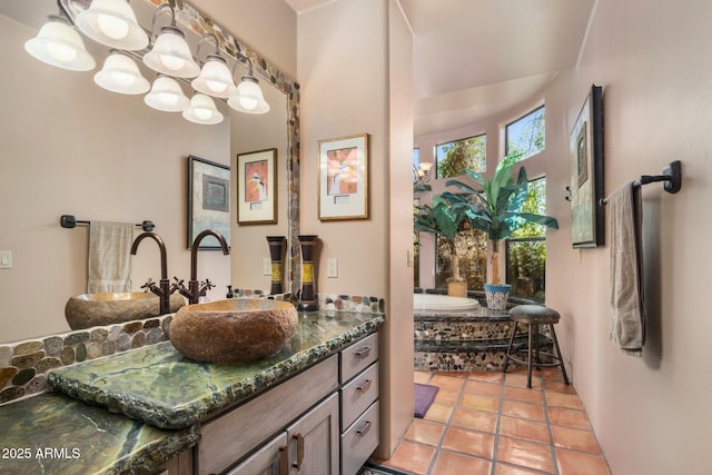 bathroom featuring a tub to relax in, tile patterned flooring, and vanity