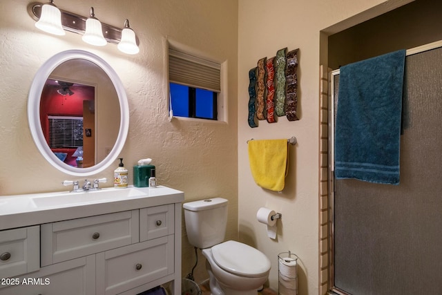 bathroom featuring vanity, an enclosed shower, and toilet