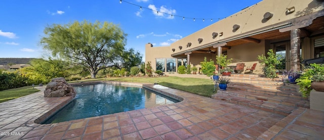 view of swimming pool with a yard and a patio area