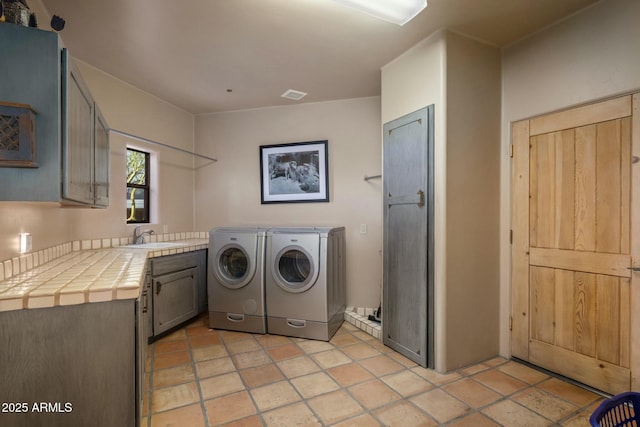 clothes washing area featuring cabinets, sink, and independent washer and dryer