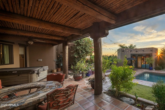 patio terrace at dusk with a swimming pool with hot tub