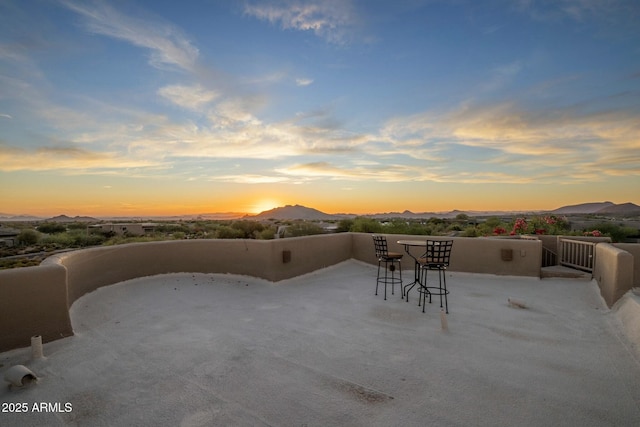 patio terrace at dusk featuring a mountain view