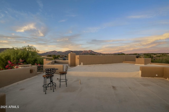 patio terrace at dusk featuring a mountain view