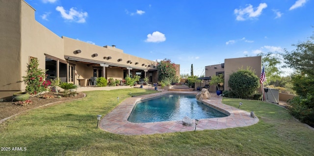 view of swimming pool featuring pool water feature, a patio area, and a lawn