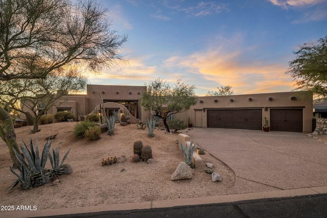 pueblo revival-style home with a garage