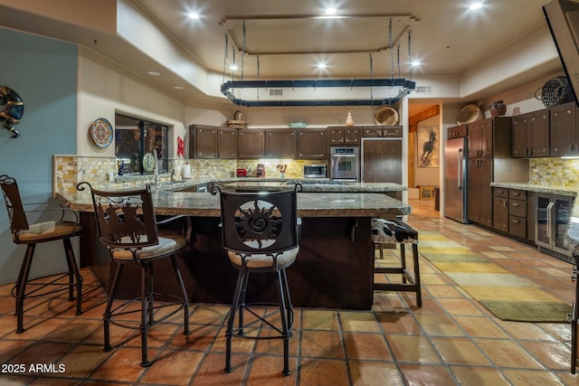 kitchen featuring stainless steel appliances, tasteful backsplash, a breakfast bar, and kitchen peninsula