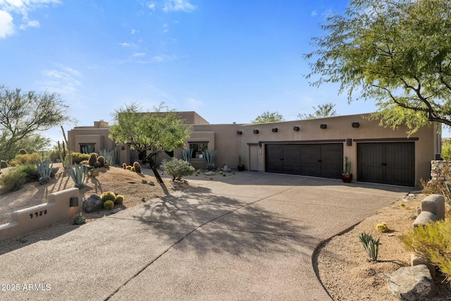 pueblo-style home featuring a garage