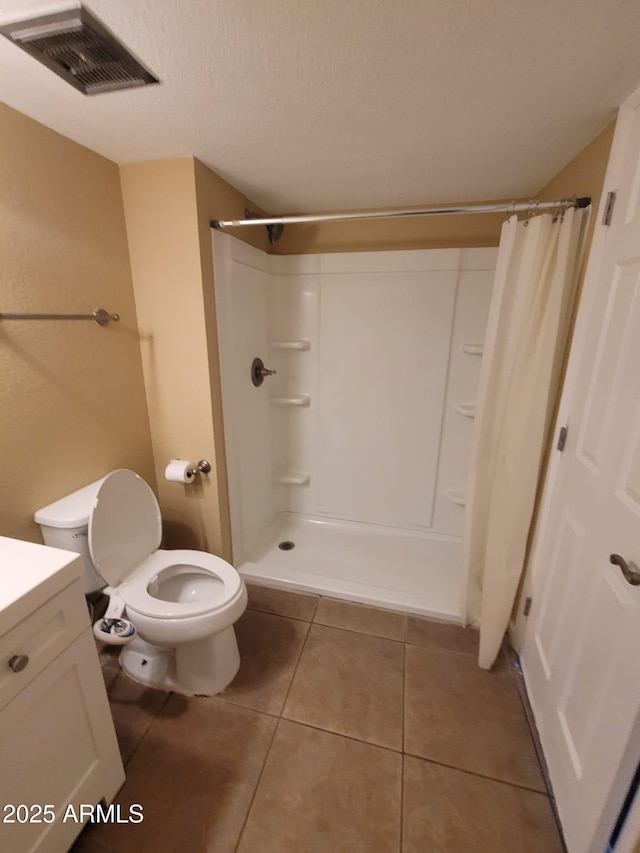 bathroom with vanity, a textured ceiling, a shower with curtain, tile patterned floors, and toilet