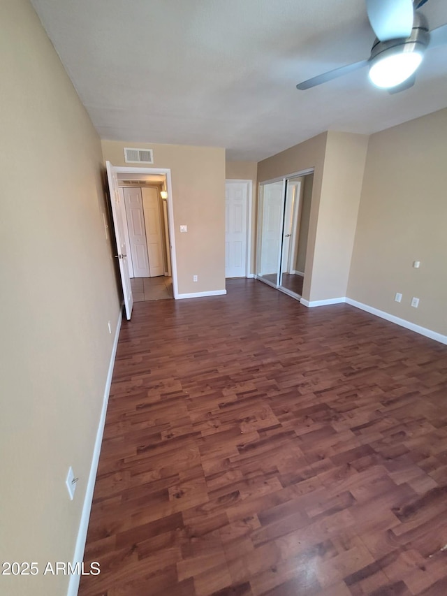 spare room featuring dark wood-type flooring and ceiling fan