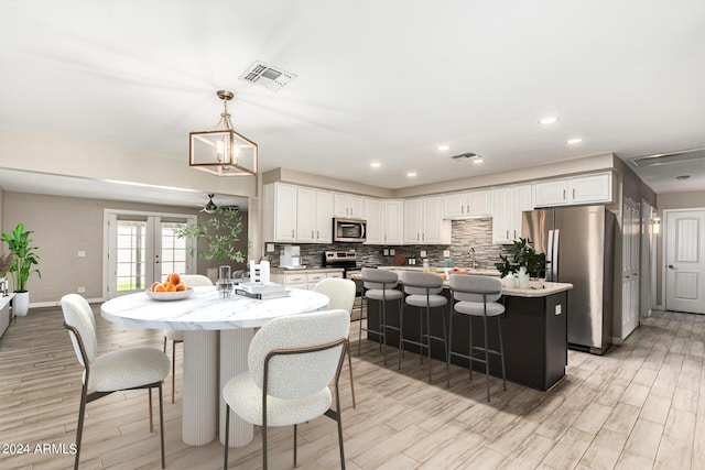 dining room featuring french doors, sink, and light wood-type flooring