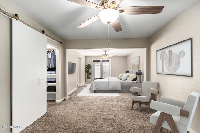 carpeted bedroom with a barn door, ceiling fan, and french doors