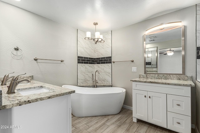 bathroom featuring ceiling fan, vanity, and a bathing tub