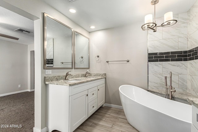 bathroom featuring vanity and a washtub