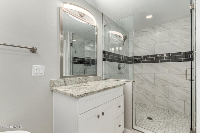 bathroom featuring vanity and a shower with shower door