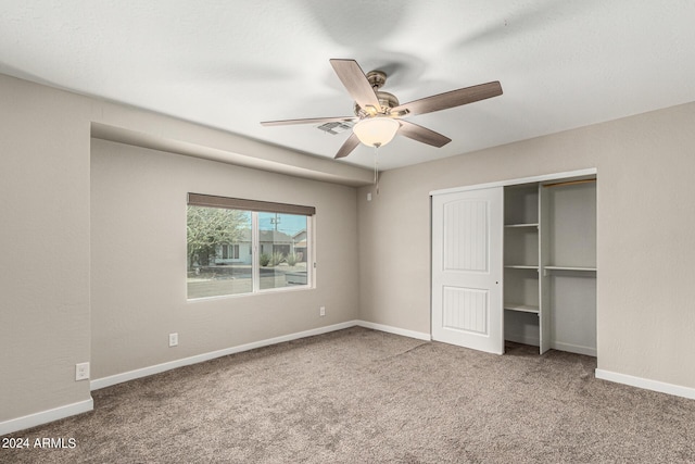 unfurnished bedroom with carpet floors, a closet, and ceiling fan