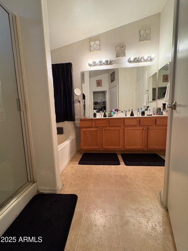 3418 W Maldonado Rd, Phoenix, AZ 85041 - full bathroom with vaulted ceiling, a bath, a shower stall, vanity, and tile patterned flooring