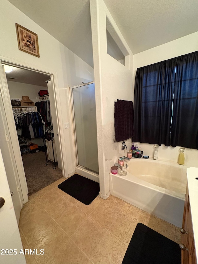 3418 W Maldonado Rd, Phoenix, AZ 85041 - bathroom featuring a shower stall, a walk in closet, a garden tub, and tile patterned flooring