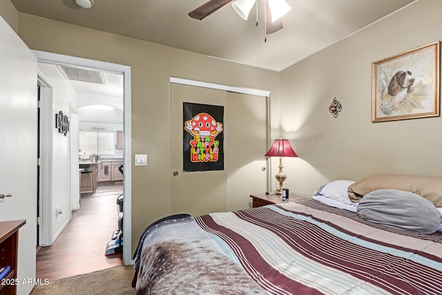 3418 W Maldonado Rd, Phoenix, AZ 85041 - bedroom with arched walkways, a closet, wood finished floors, and ceiling fan