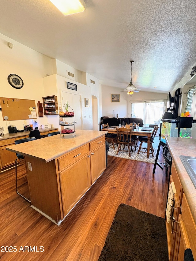 3418 W Maldonado Rd, Phoenix, AZ 85041 - kitchen with open floor plan, a ceiling fan, a textured ceiling, a center island, and dark wood finished floors
