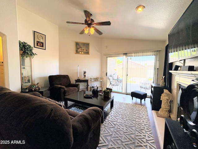 3418 W Maldonado Rd, Phoenix, AZ 85041 - living area featuring vaulted ceiling, ceiling fan, a glass covered fireplace, and wood finished floors