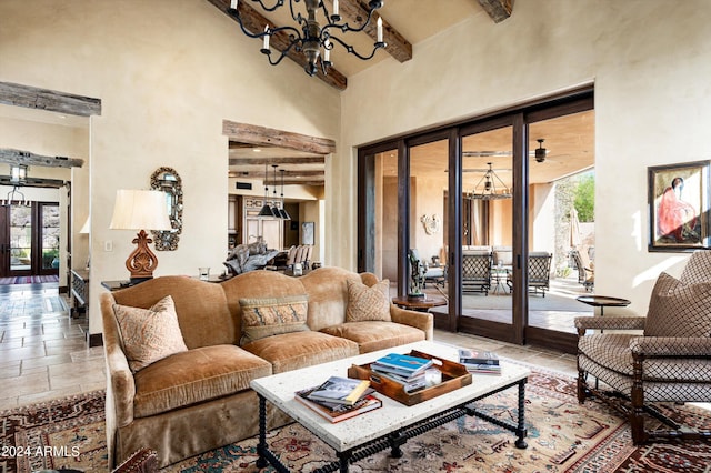 living room with beam ceiling, french doors, an inviting chandelier, and a towering ceiling