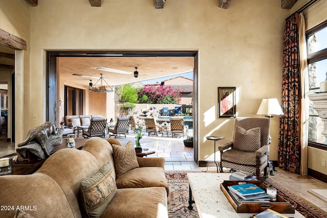 living area with baseboards, stone tile flooring, and a high ceiling