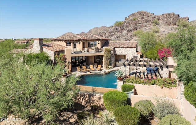 view of swimming pool with a mountain view, an outdoor living space, a patio, and a pool with connected hot tub