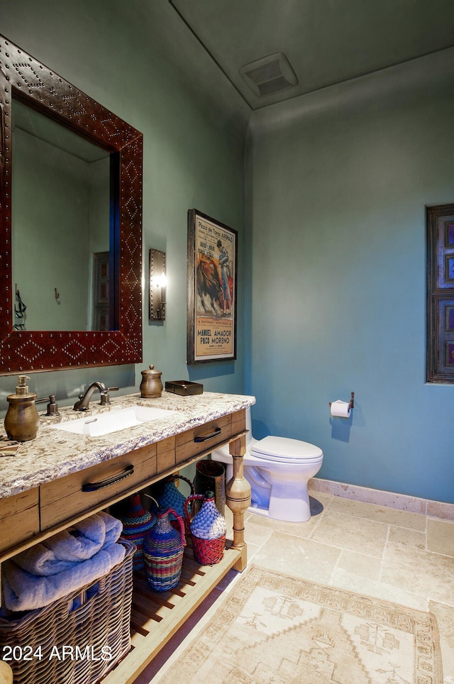 bathroom featuring visible vents, toilet, baseboards, and vanity