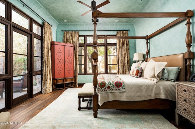 bedroom featuring multiple windows, hardwood / wood-style floors, and ceiling fan