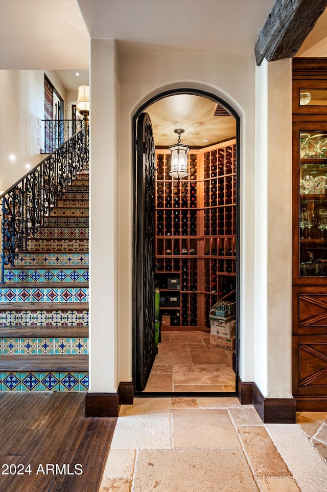 wine cellar with stone tile floors, baseboards, and arched walkways