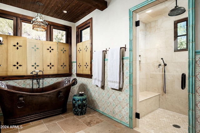 bathroom with a shower stall, baseboards, wood ceiling, and plenty of natural light