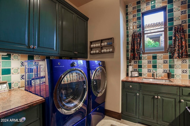 washroom with sink, independent washer and dryer, and cabinets