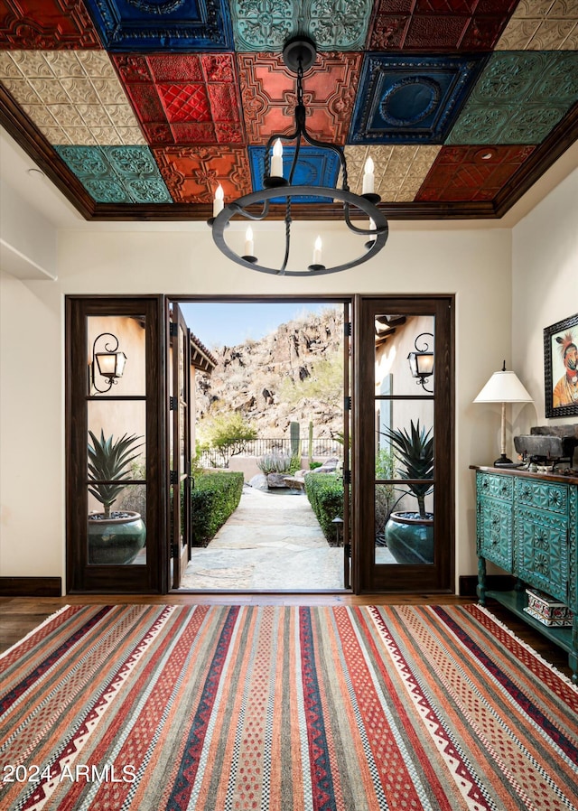 foyer featuring crown molding and a notable chandelier