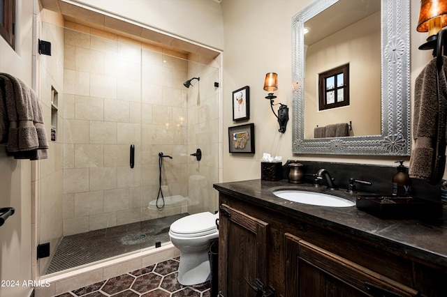 bathroom with vanity, tile patterned flooring, toilet, and an enclosed shower