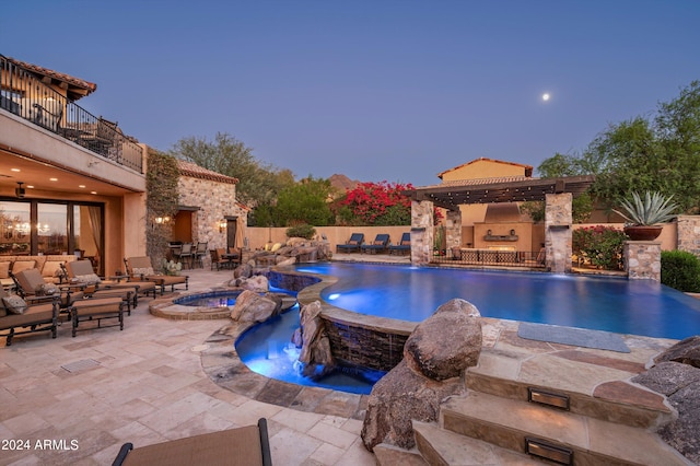 pool at dusk featuring outdoor lounge area, an in ground hot tub, pool water feature, and a patio