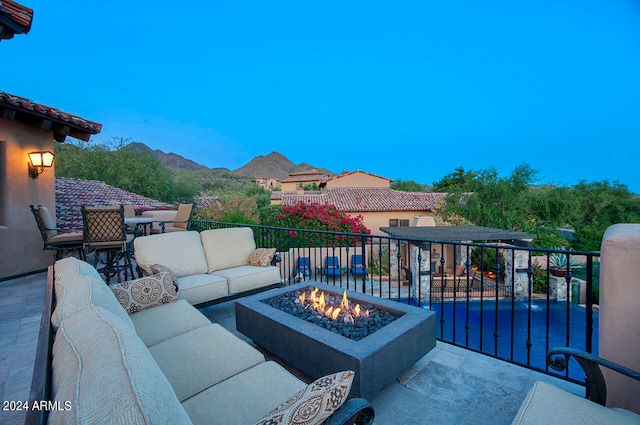 view of patio / terrace with a mountain view, an outdoor living space with a fire pit, and a balcony