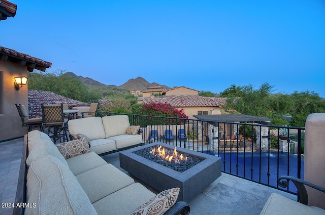 view of patio with an outdoor living space with a fire pit and a balcony