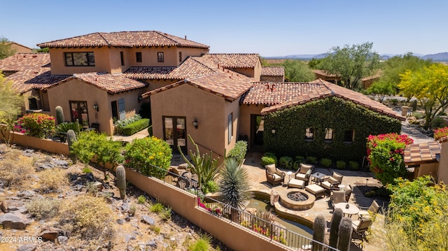 rear view of property with an outdoor fire pit and a patio