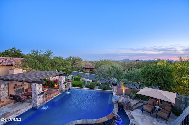 pool at dusk with a patio area and an outdoor pool